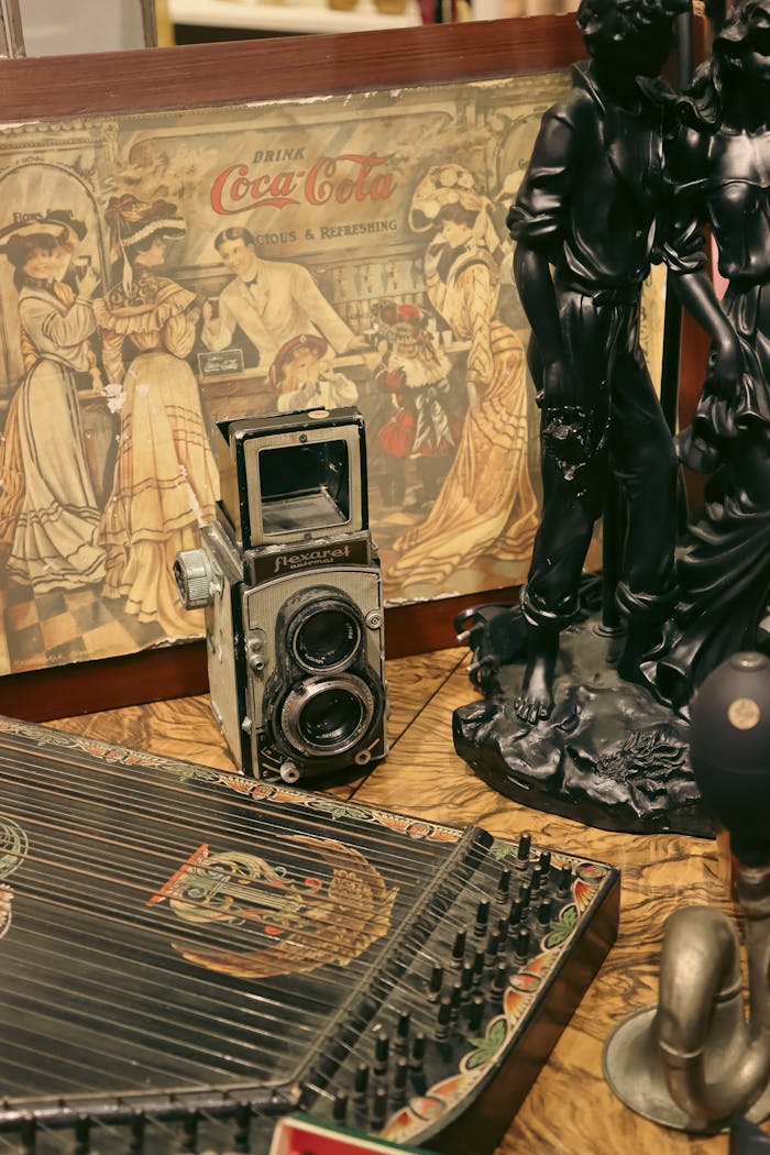 services-01 An assortment of vintage antiques featuring an old camera, figurines, and a Coca-Cola advertisement.